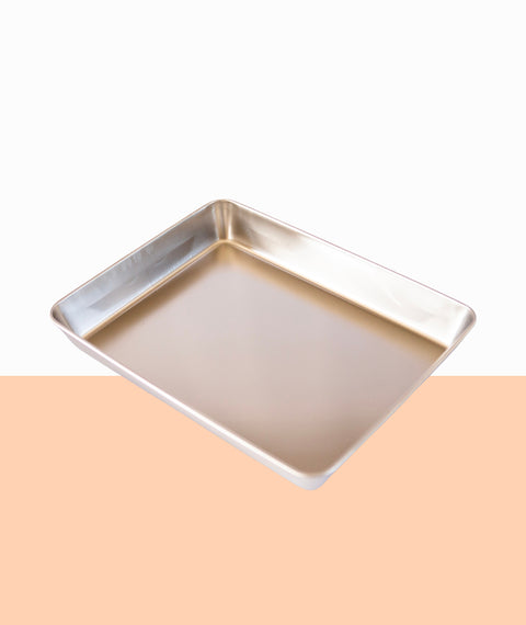 Metal scrap rectangle tray on a peach and white background